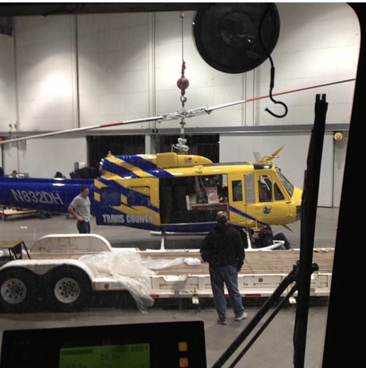 Two men standing near a mobile crane from Langford Crane Service, Inc., with a yellow helicopter in the background, demonstrating 50-ton crane rental in Las Vegas.